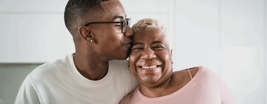 Young adult and parent sharing a warm moment in a bright kitchen, reflecting how ADUs help families stay connected while supporting independence.